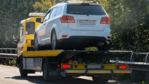 Grúa de plataforma transportando por carretera un coche que no puede circular por sí mismo