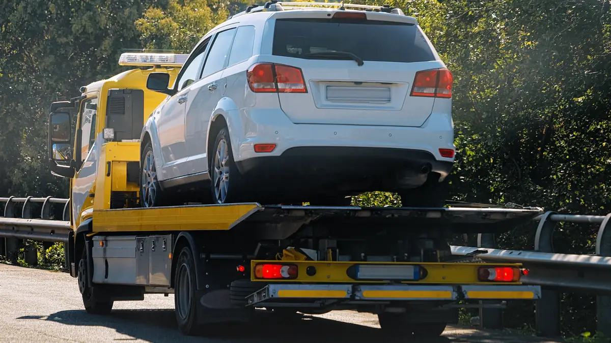 Grúa de plataforma transportando por carretera un coche que no puede circular por sí mismo